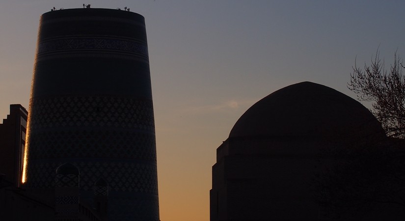 城壁に囲まれた世界遺産ヒヴァ　夕陽、飛行機雲、太っちょミナレット